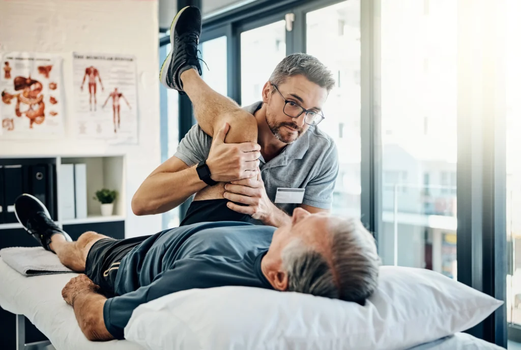 physical therapist stretching his patient's knee to treat unwanted knee pain