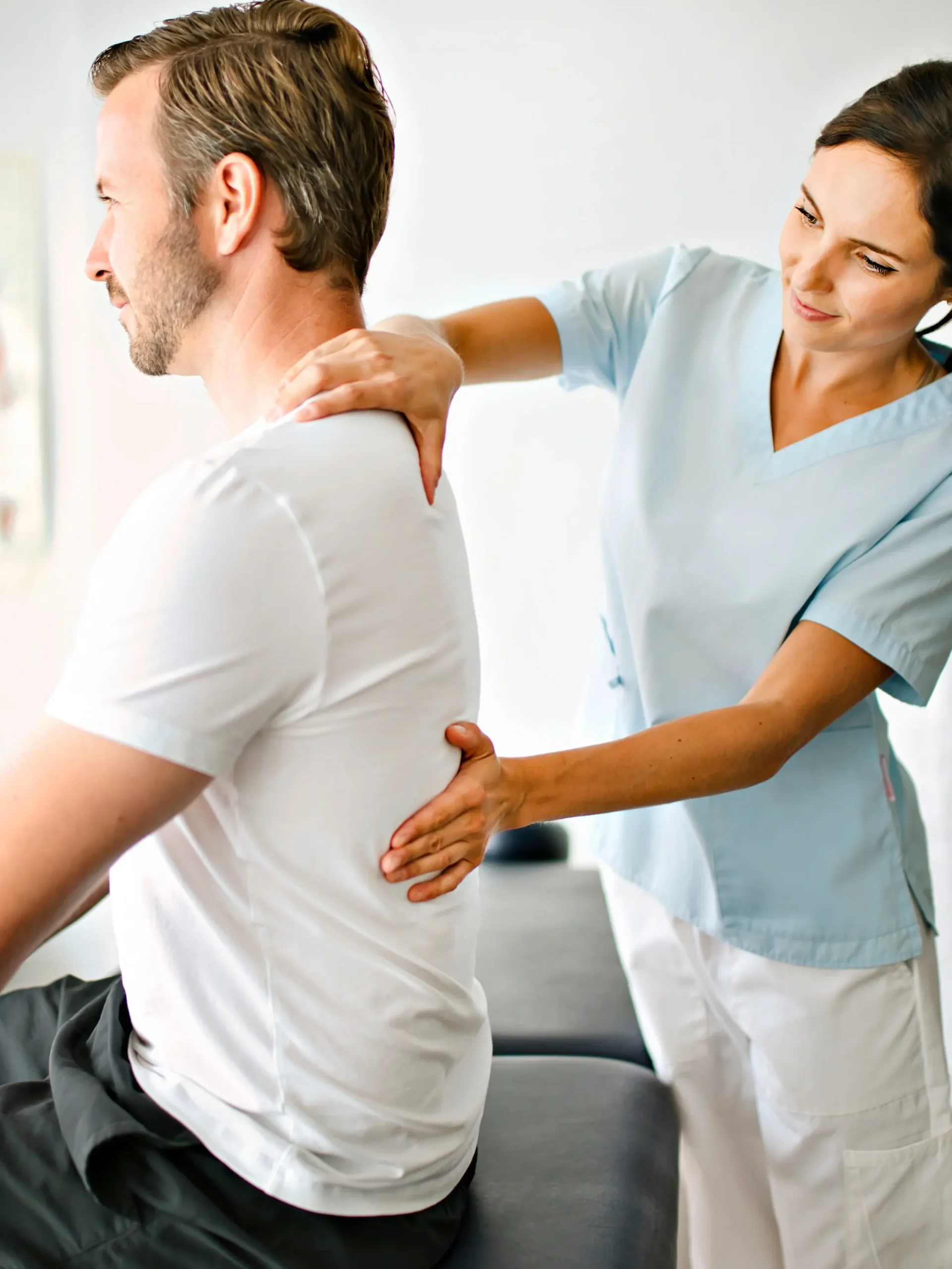 Therapist working with patient on posture, hands on back sitting upright