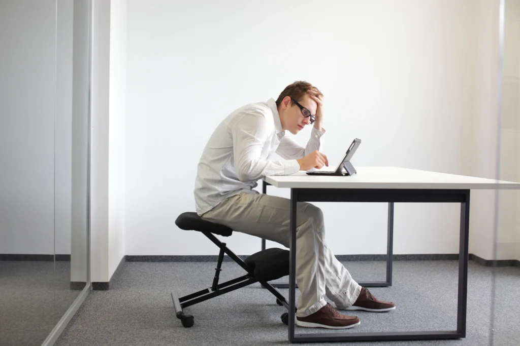 Man in white shirt with poor posture at desk
